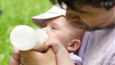 一个阳光明媚的夏天，一位年轻的父亲在公园里用奶瓶喂他的小儿子